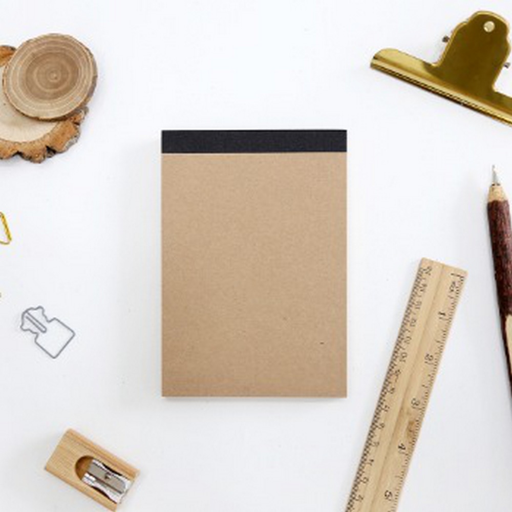 Skizzenbuch aus Kraftpapier, All Kraft Drawing Book umgeben von Lineal, Stift, Anspitzer und Klammer.